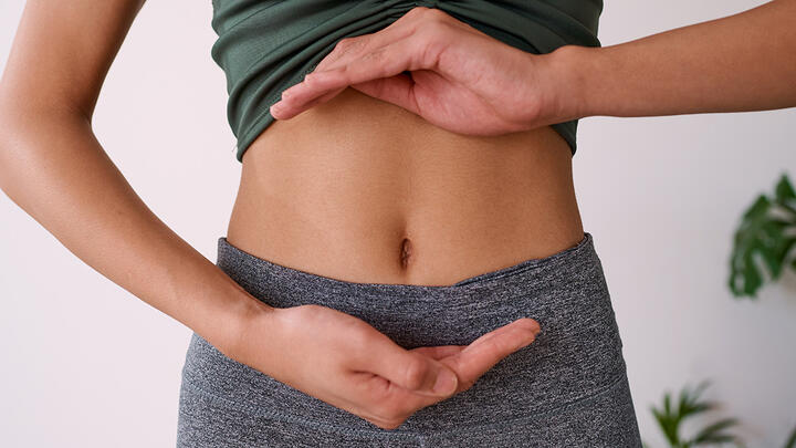 Closeup of female hands holding an invisible circle around the belly
